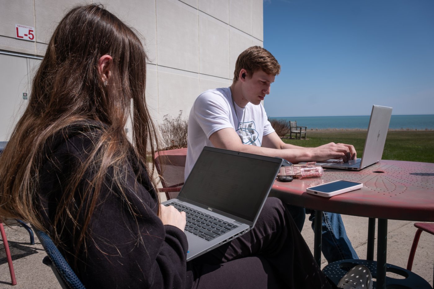 Two students sitting outside studying.