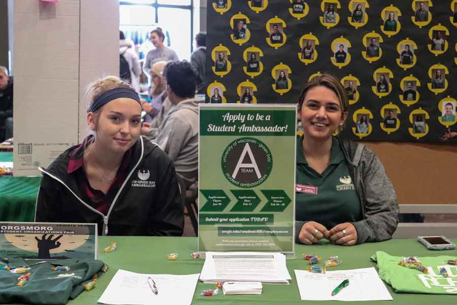 Two student ambassadors at booth promote the Student Ambassador opportunity
