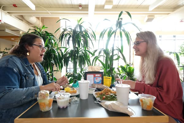 students talking over lunch in the Cloud Commons cafeteria