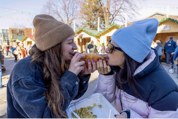 Two students eat brats at event