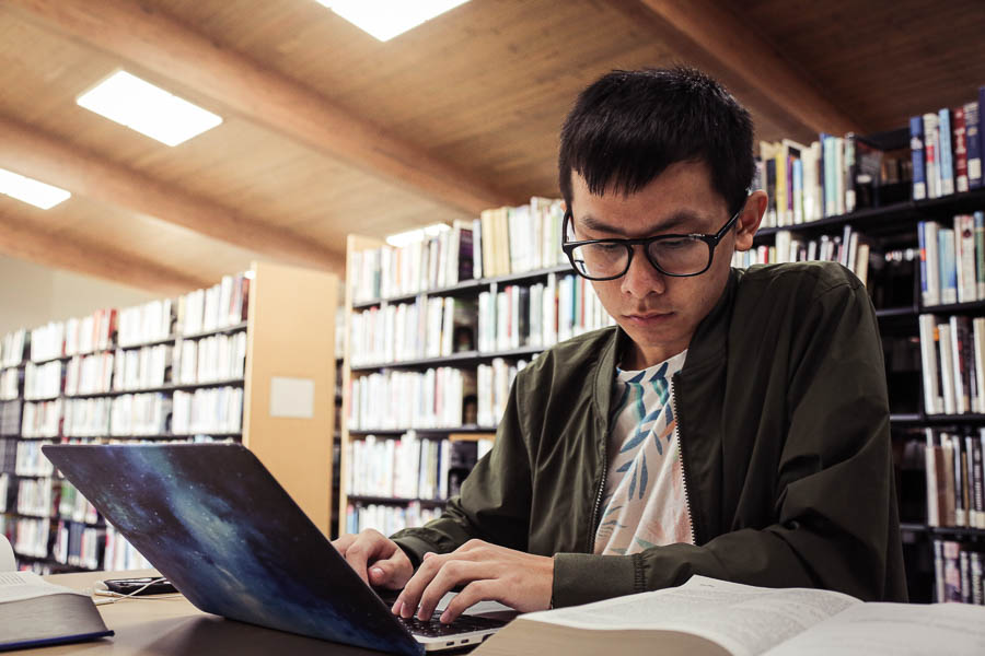 Student in a campus library using a laptop