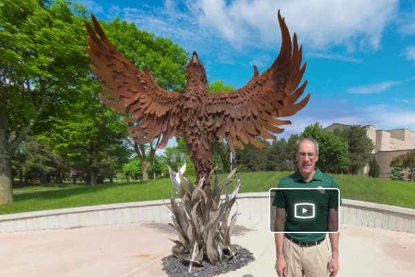 Chancellor Alexander standing by the Phoenix Statue.