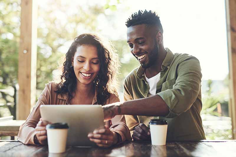 woman and man looking at digital table at cafe table