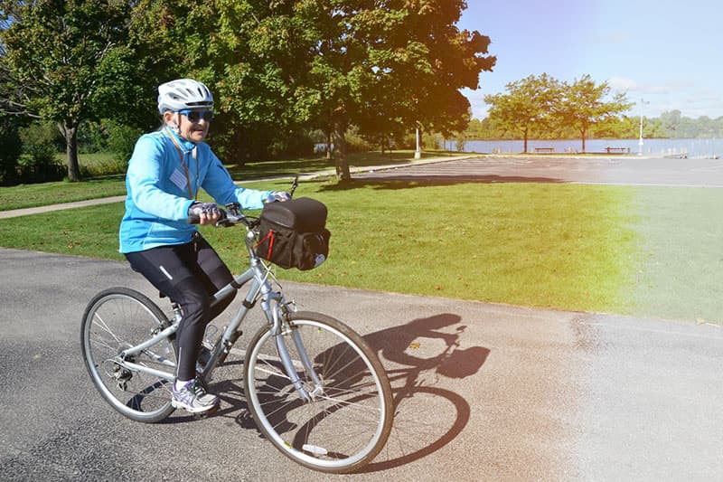 Woman riding bicycle on paved trail