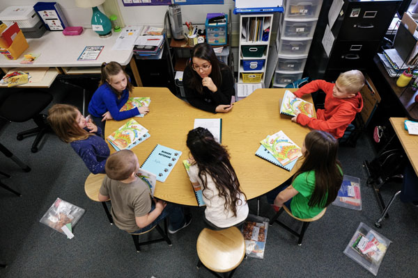 Elementary Education student teaching young kids at table