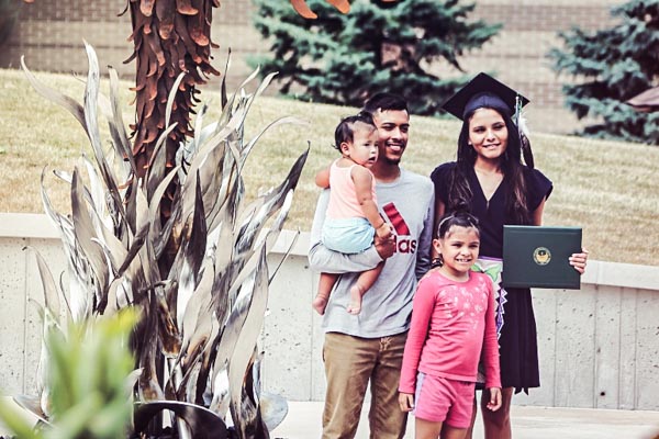 Graduating indigenous student posing for a photo with family