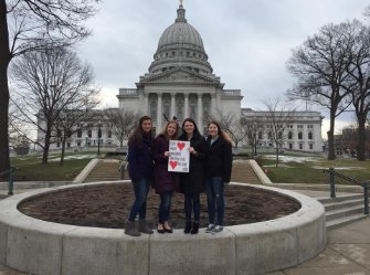Group of four people in front of a the capitol building