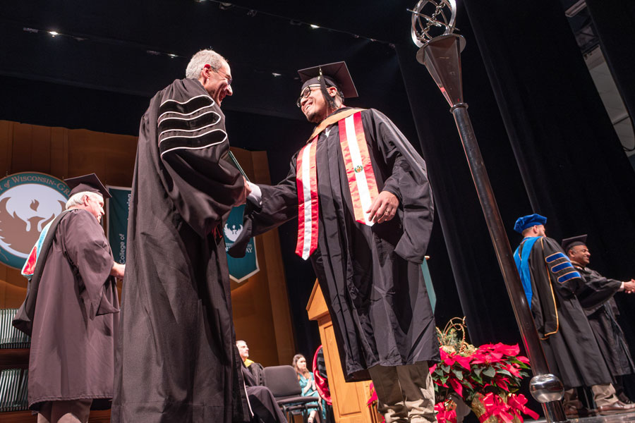 Chancellor Michael Alexander shakes had with Master's Graduate