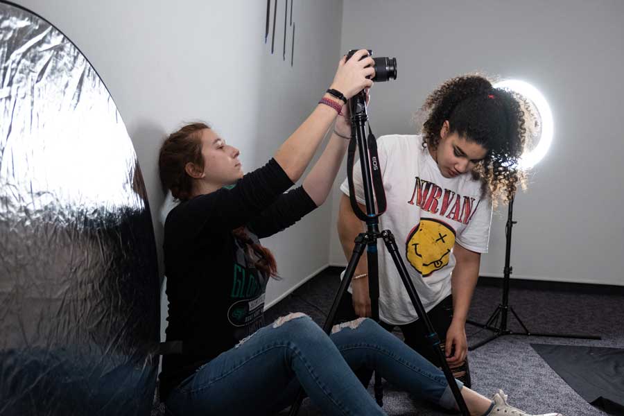 Two students set up space for photo shoot