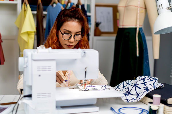 Costume designer works at sewing machine
