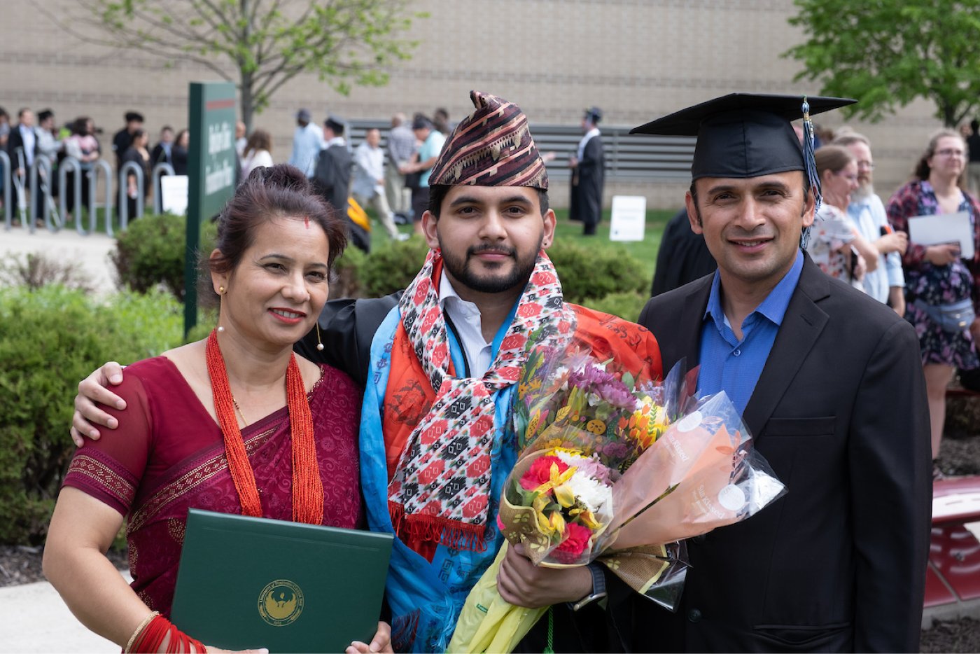 A family poses for a photo after the Commencement ceremony.