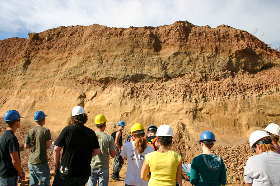 Students study on site of large rock formation