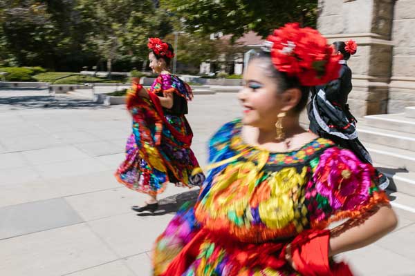 Two females dance in traditional Mexican dress