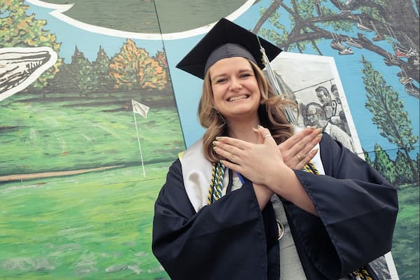 Female student poses for photo at commencement ceremony