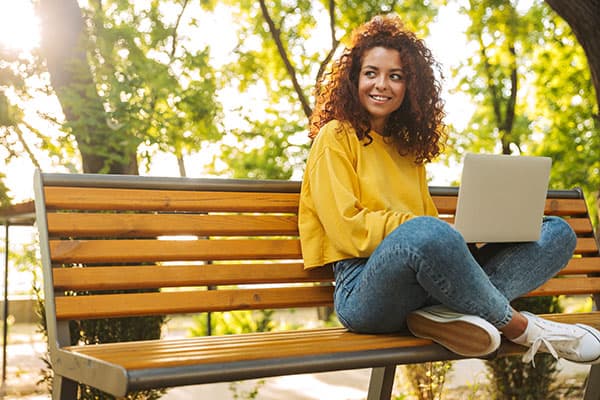 cheerful student sitting outside on a bench