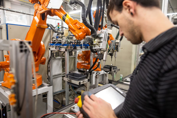 Employee working on programming automotive robot