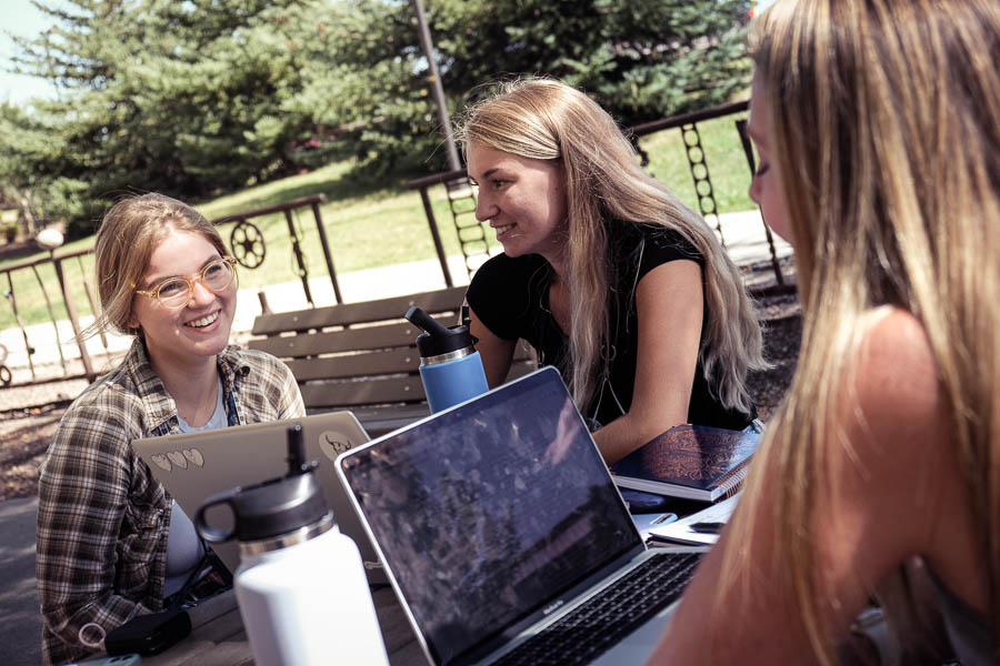students talking at an outdoor table at uwgb