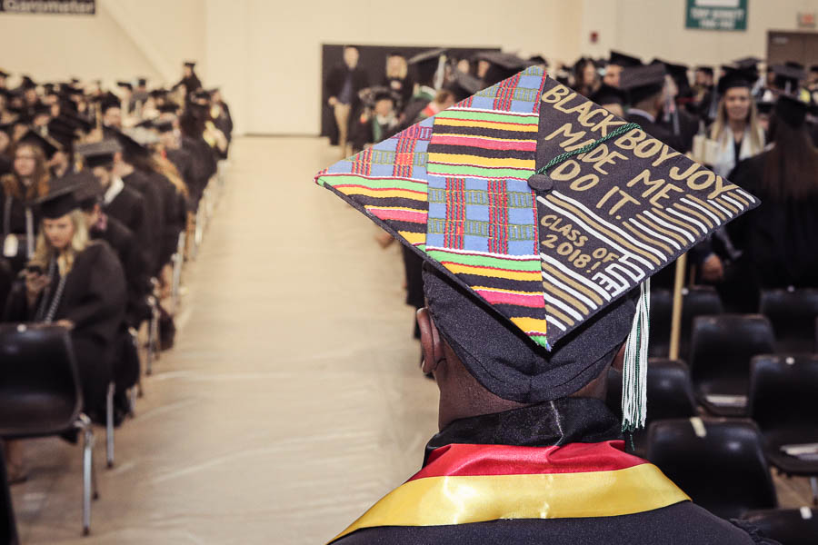 A graduate walking away wearing their grad cap.