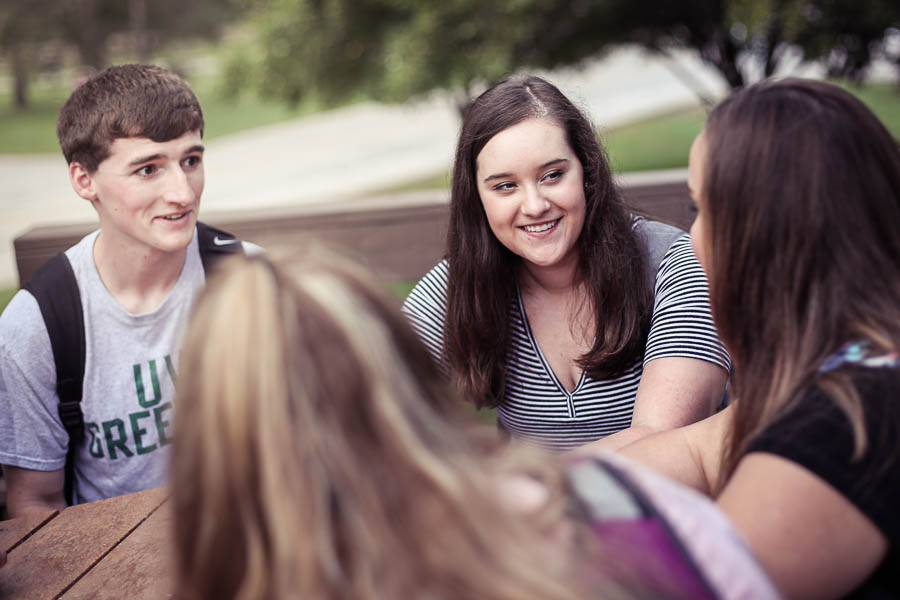 students talk at an outdoor table at uwgb