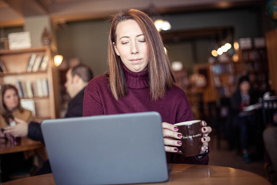 Non-traditional student on laptop in a coffee shop