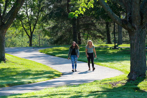 Two students walking outdoors on campus