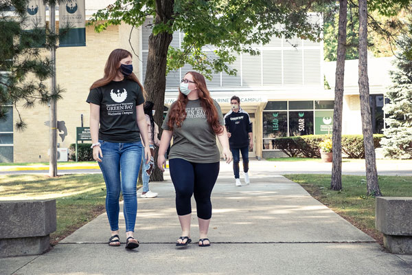 UWGB students walking on the sidewalk between Marinette Campus buildings.