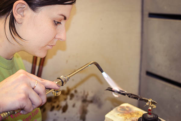 Art metals student using torch to heat her project