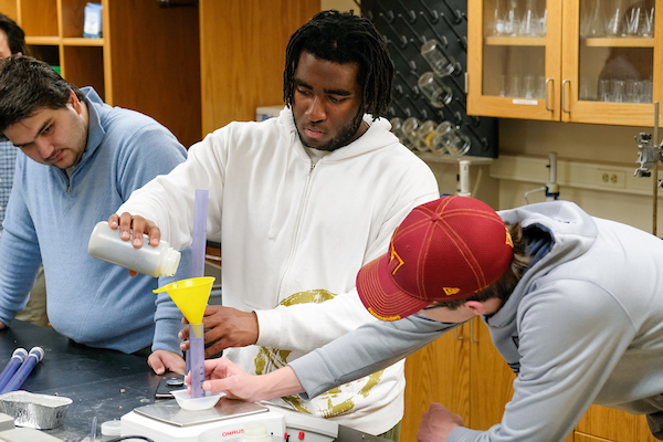 Three students conducting an experiment in a Sustainable Management course.