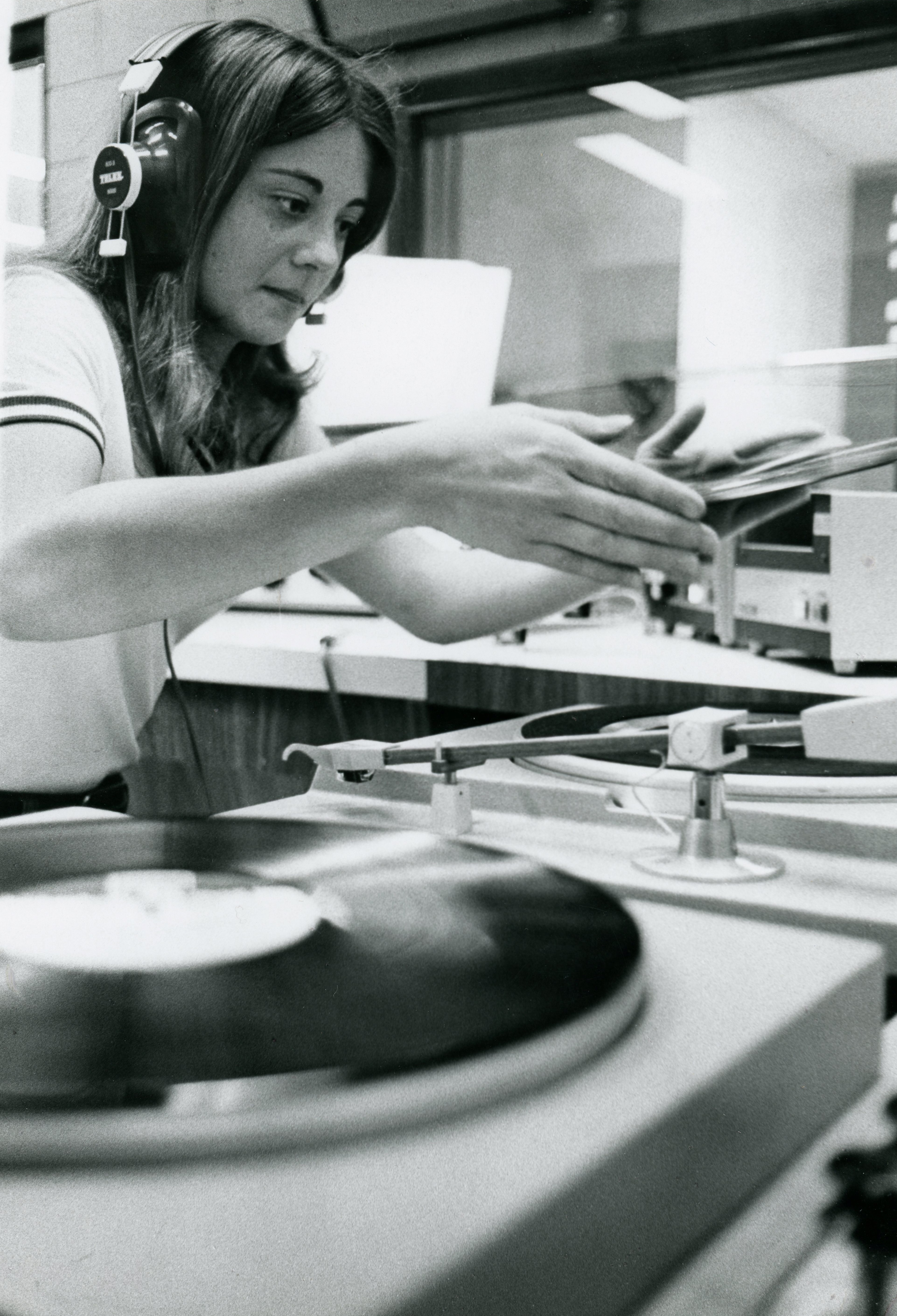 Student puts a record on the turntable at the campus radio station