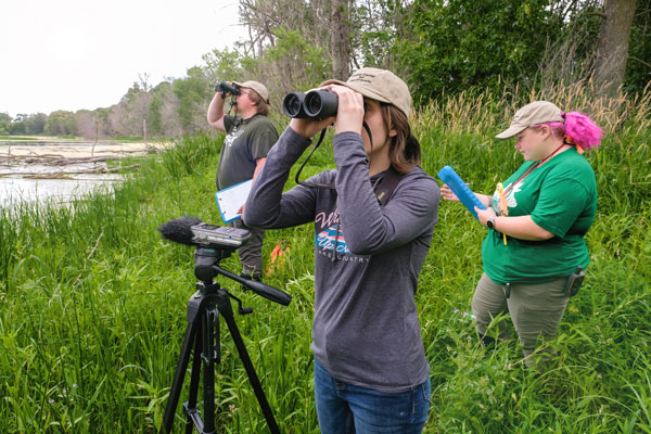 Students research outside with binoculars