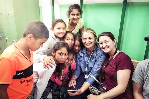 Community Health worker poses with children in Mexico