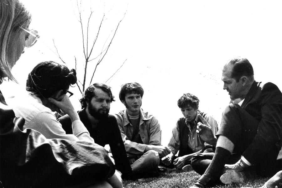 Founding Chancellor Ed Weidner seated on the ground with UW-Green Bay students, circa 1974