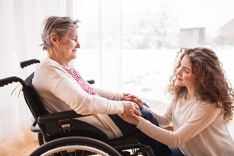 Woman caring for elderly person in wheelchair