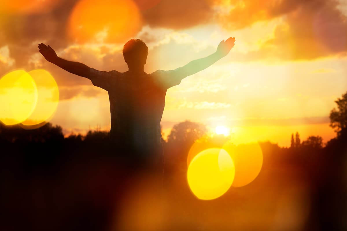 Person outside with arms raised