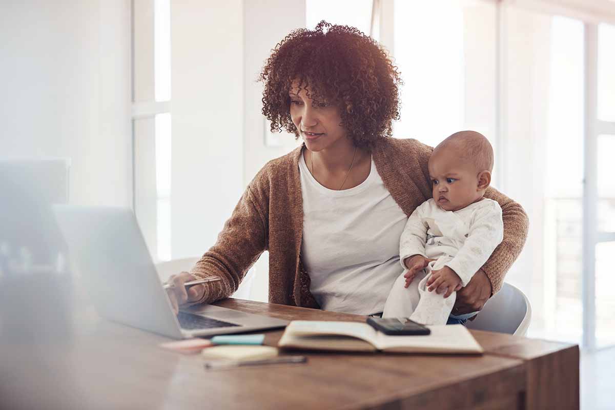 Woman studying online with a child on her lap