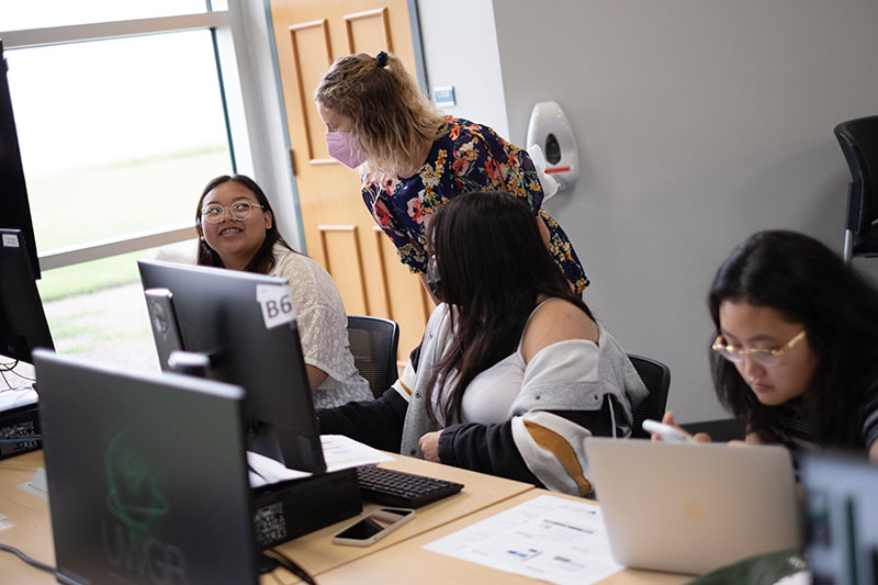 advisor answering a students questions in computer lab