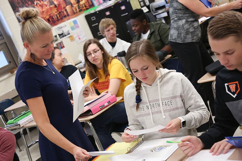 teacher working with student during French class