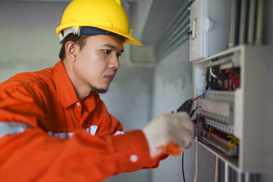 Professional electrician wears hard hat on job site