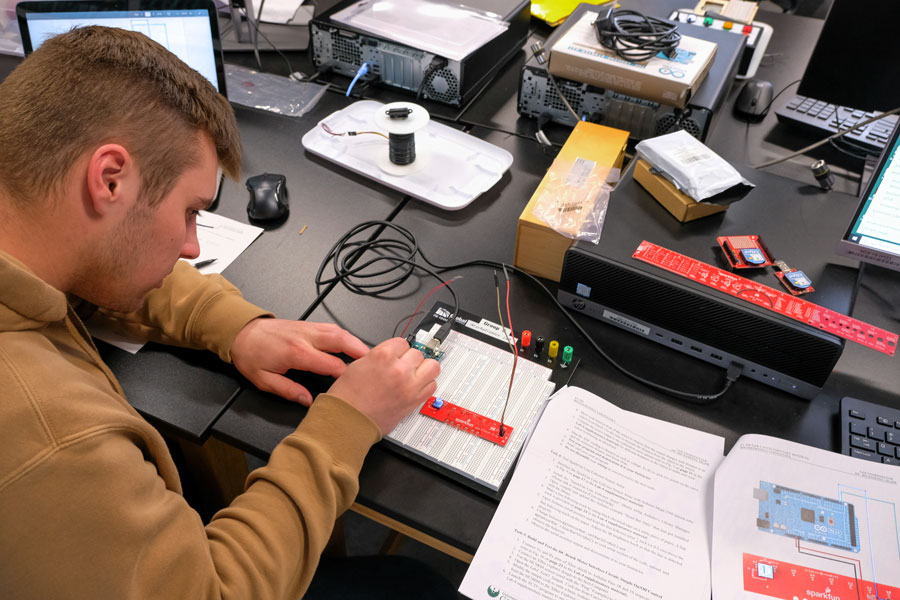 Student working on electrical engineering technology in class