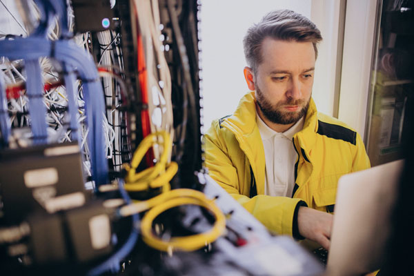 Electrician works at computer on site