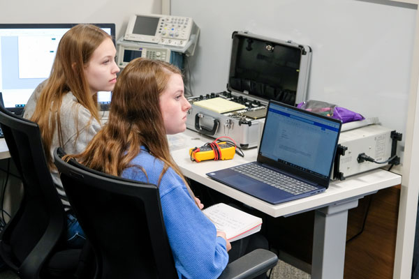 Two female students work at computers