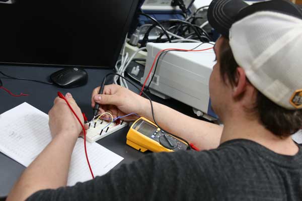 Male student works on circuit board