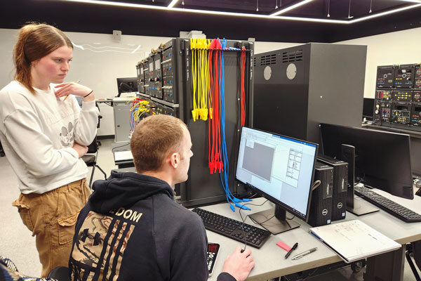 Male and female student work at computer in lab