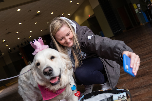 A student taking a selfie with a dog