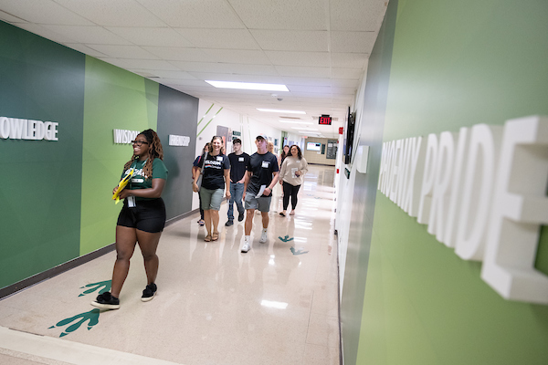 A student ambassador leads students and their families through the halls on a tour of UW-Green Bay.