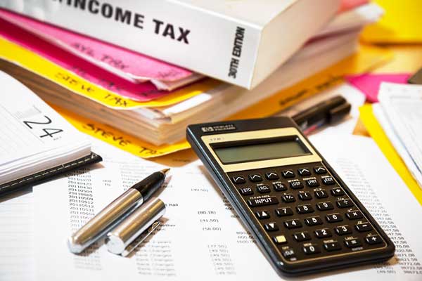 Calculator by a stack of books about taxes