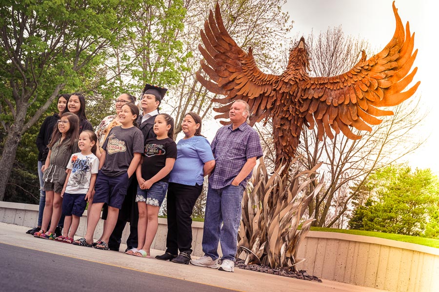 family at phoenix statue with graduate