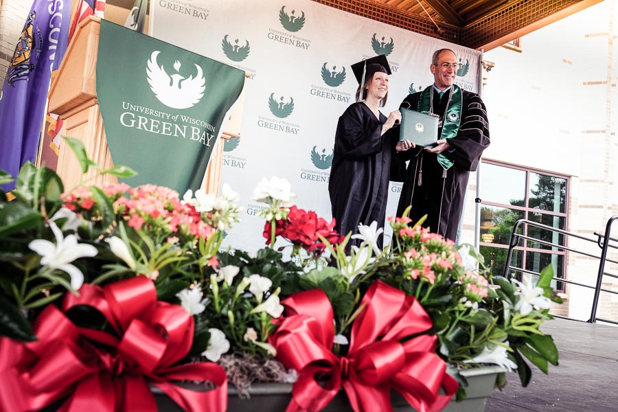 student graduating on stage with chancellor Alexander