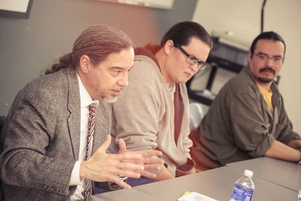 Professors speak to students in class