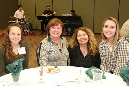 Four people at a table at a fundraising event